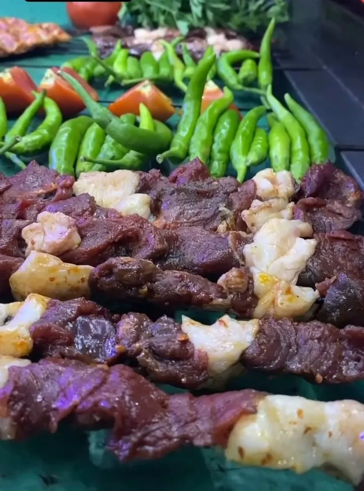 Vitrinde şişler; yanında yeşil biber ve domates
